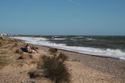 2 people sitting on walberswick beach