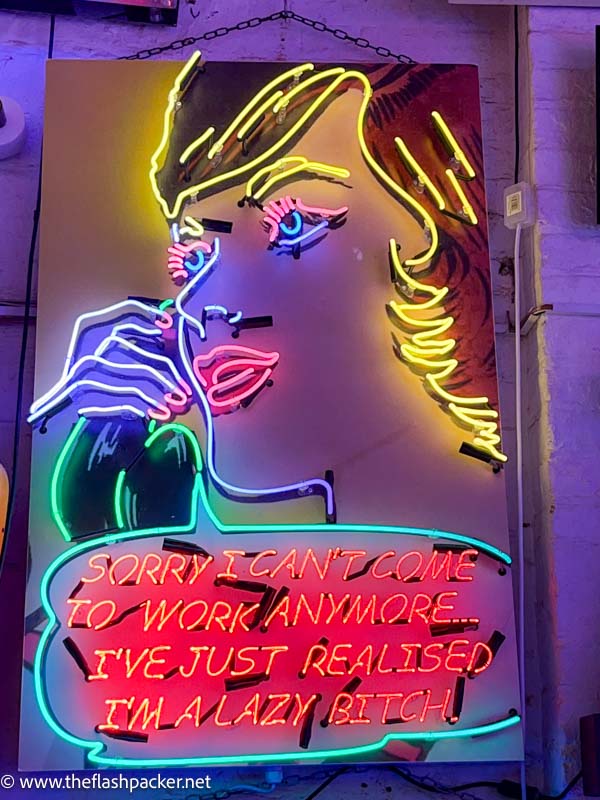 neon sign of a womans face with slogan