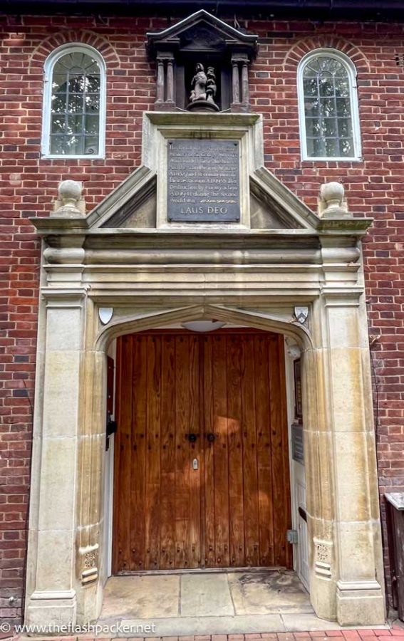 doorway to an old school building below a commemorative plaque