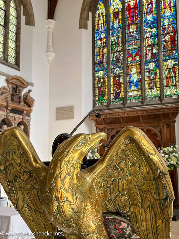 bronze lectern in the shape of an eagle in front of altar and stained glass window