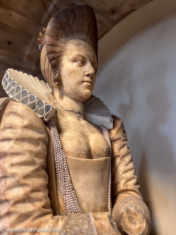 marble effigy of woman in profile wearing a ruff