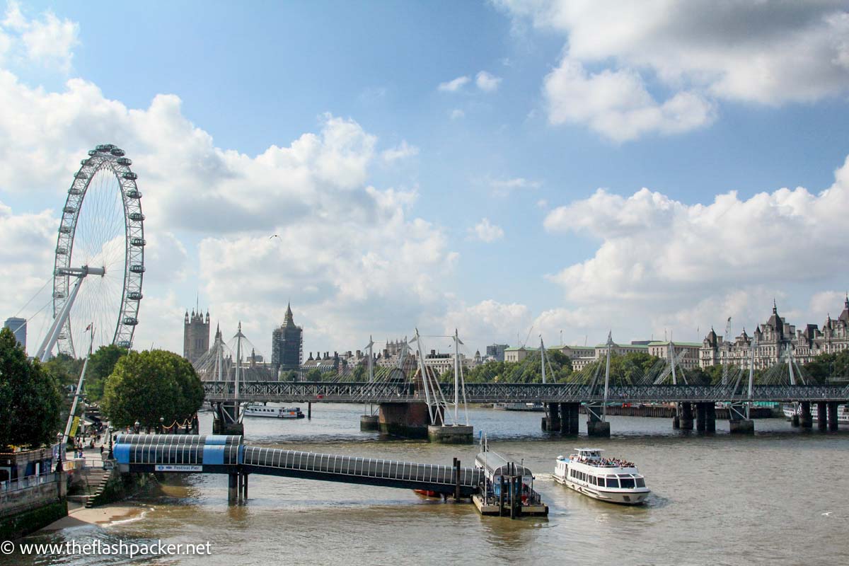 view across river thames in london with bridge london eye and the gothic palace of westminster