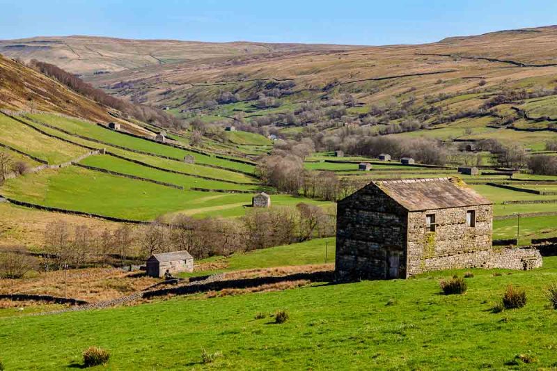 rolling fields and stone barn in valley