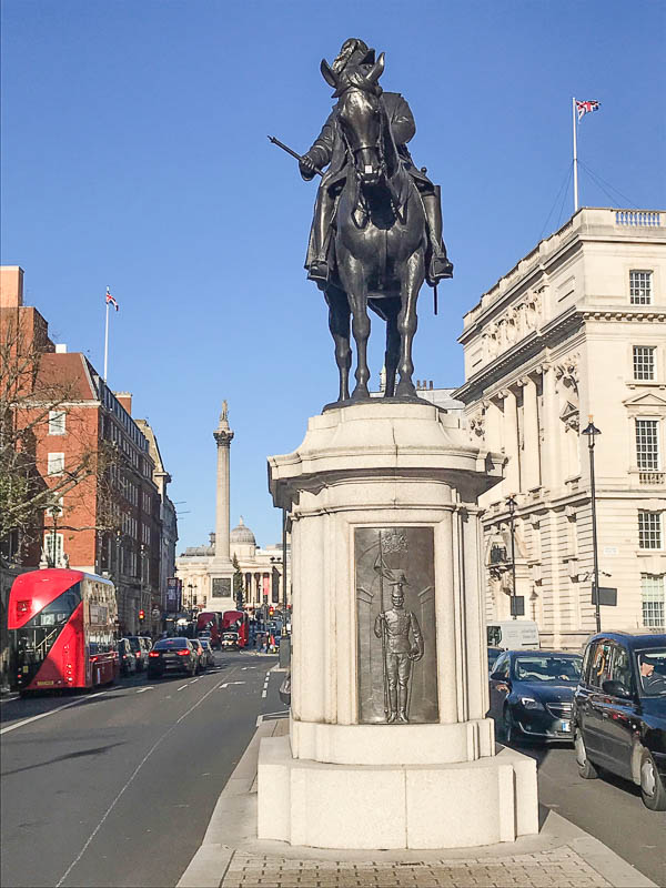 statue of soldier on horseback in the middle of the london street called whitehall