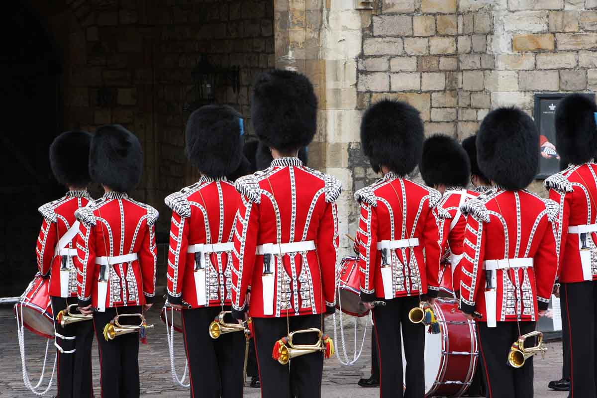 beefeater guards dressed in red and black uniformes and furry hats