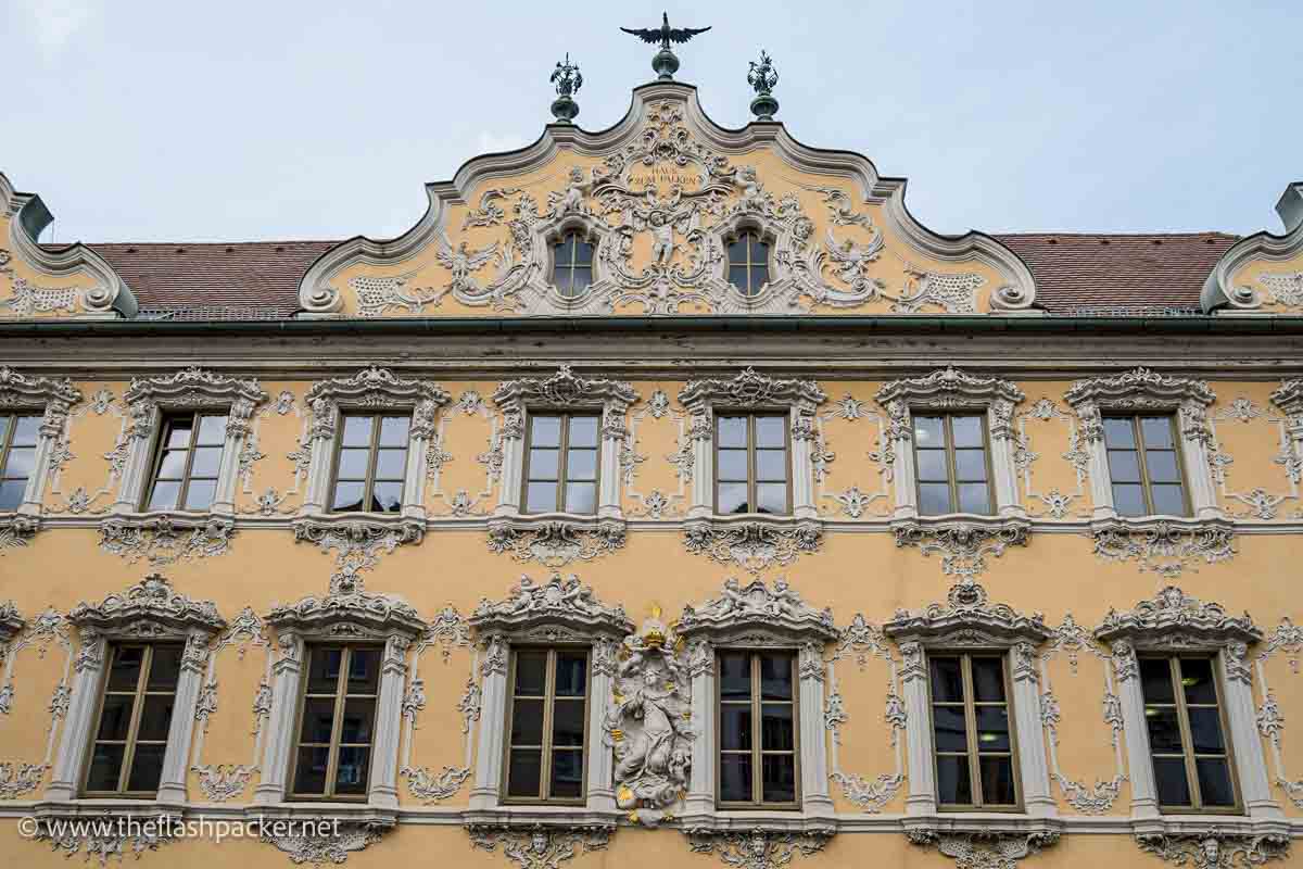 yellow stucco facade of the house of the falcon in wurzburg germany