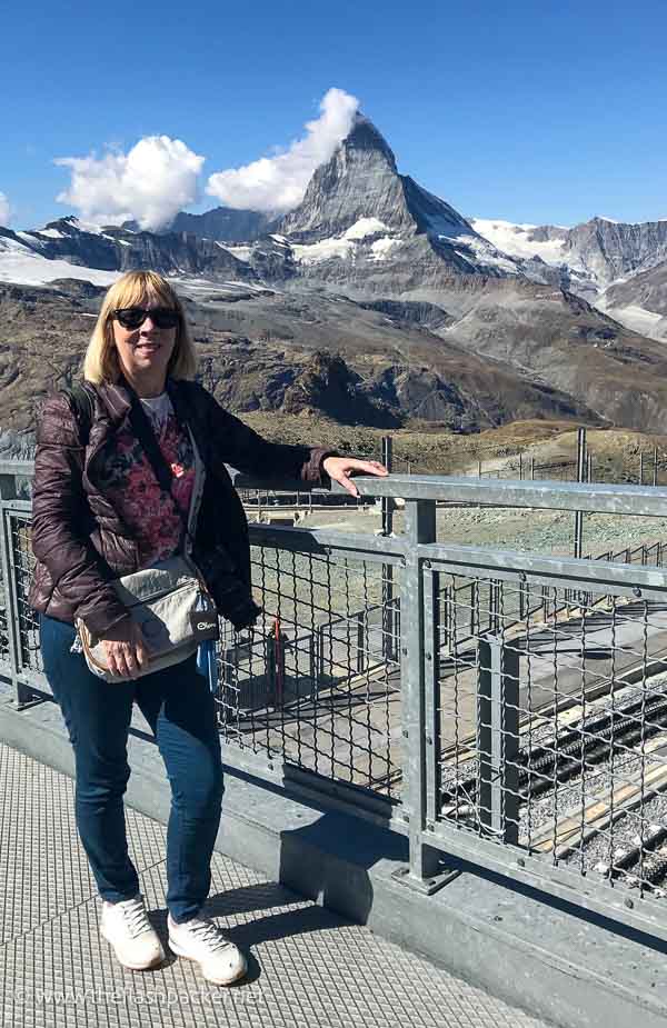 woman with blonde hair standing in front of the matterhorn mountain near zermatt switzerland